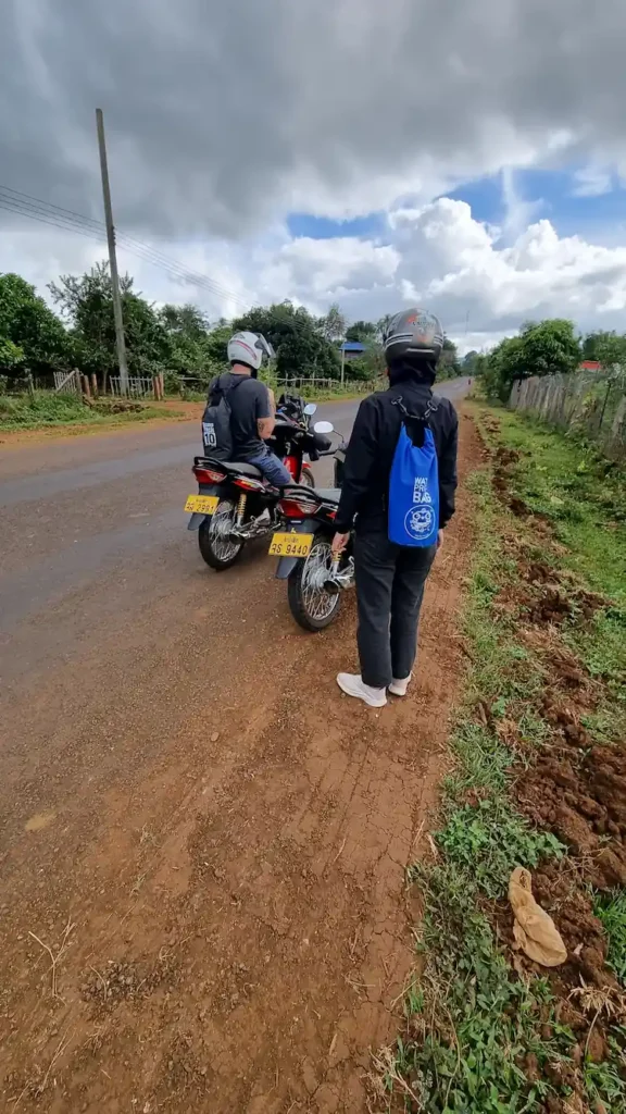 motorrad fahren in laos, zwei personen am straßenrand bolaven plateau straße